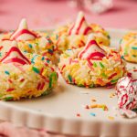 Close-up side view of soft sugar cookie blossoms with rainbow sprinkles and Hershey’s Hugs on top.