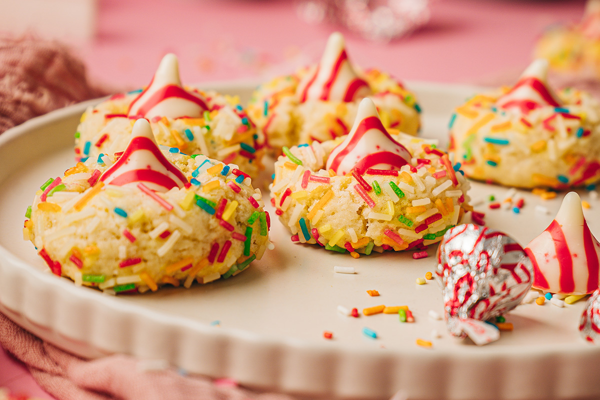 Close-up side view of soft sugar cookie blossoms with rainbow sprinkles and Hershey’s Hugs on top.