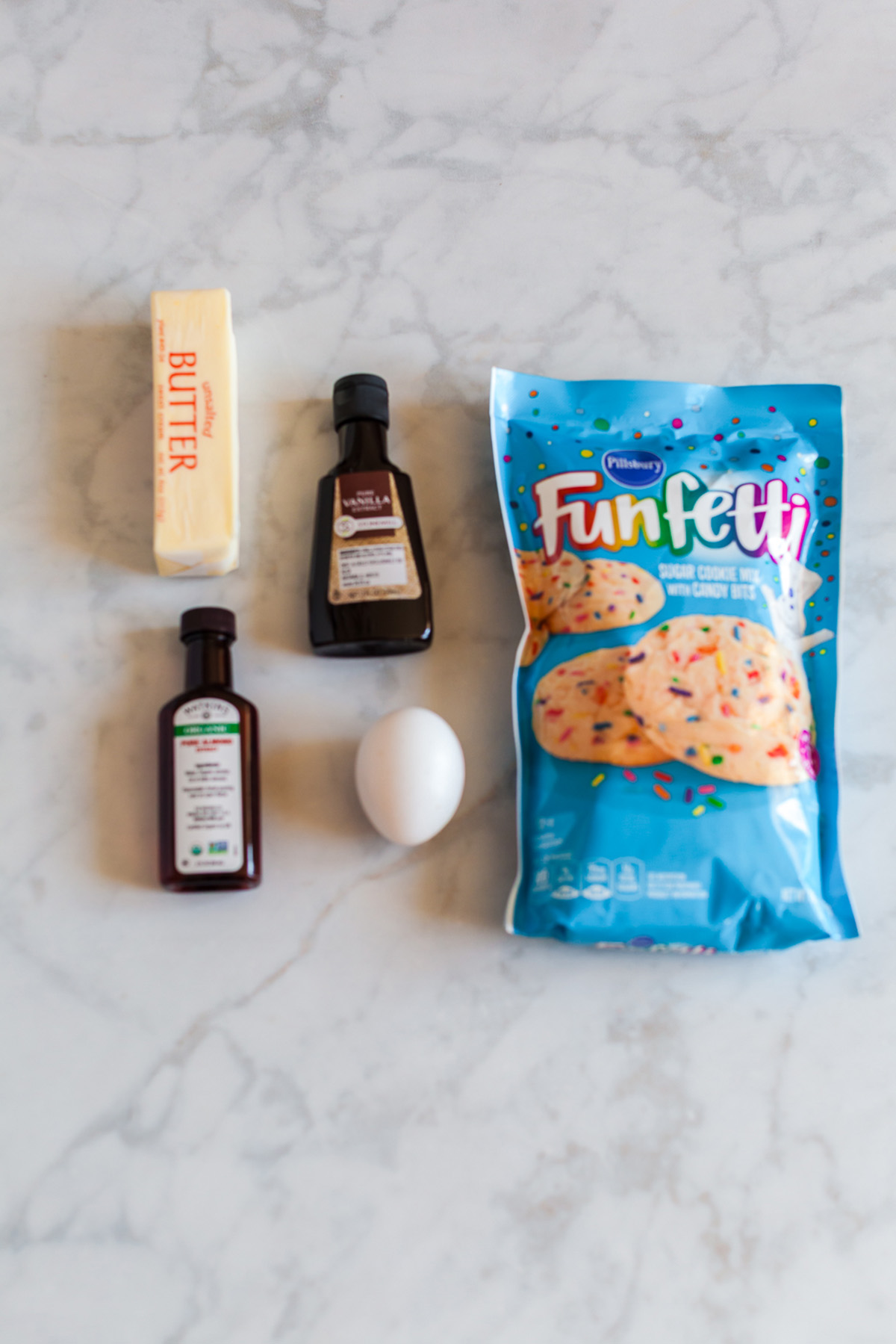 These funfetti sugar cookie bars start with a shortcut and bake up soft, buttery, and packed with sprinkles. Finished with a thick layer of pink frosting, they’re the kind of treat that disappears fast. Ingredients for funfetti sugar cookie bars including cookie mix, butter, egg, vanilla, and almond extract.