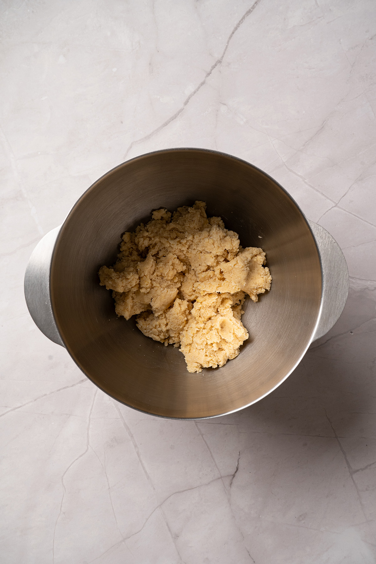 These cream cheese sugar cookies are soft, sweet, and topped with fluffy frosting. Starting with sugar cookie mix keeps them easy, but they still feel special enough for parties and holidays. Cream cheese sugar cookie dough made with sugar cookie mix in a stand mixer bowl after mixing.