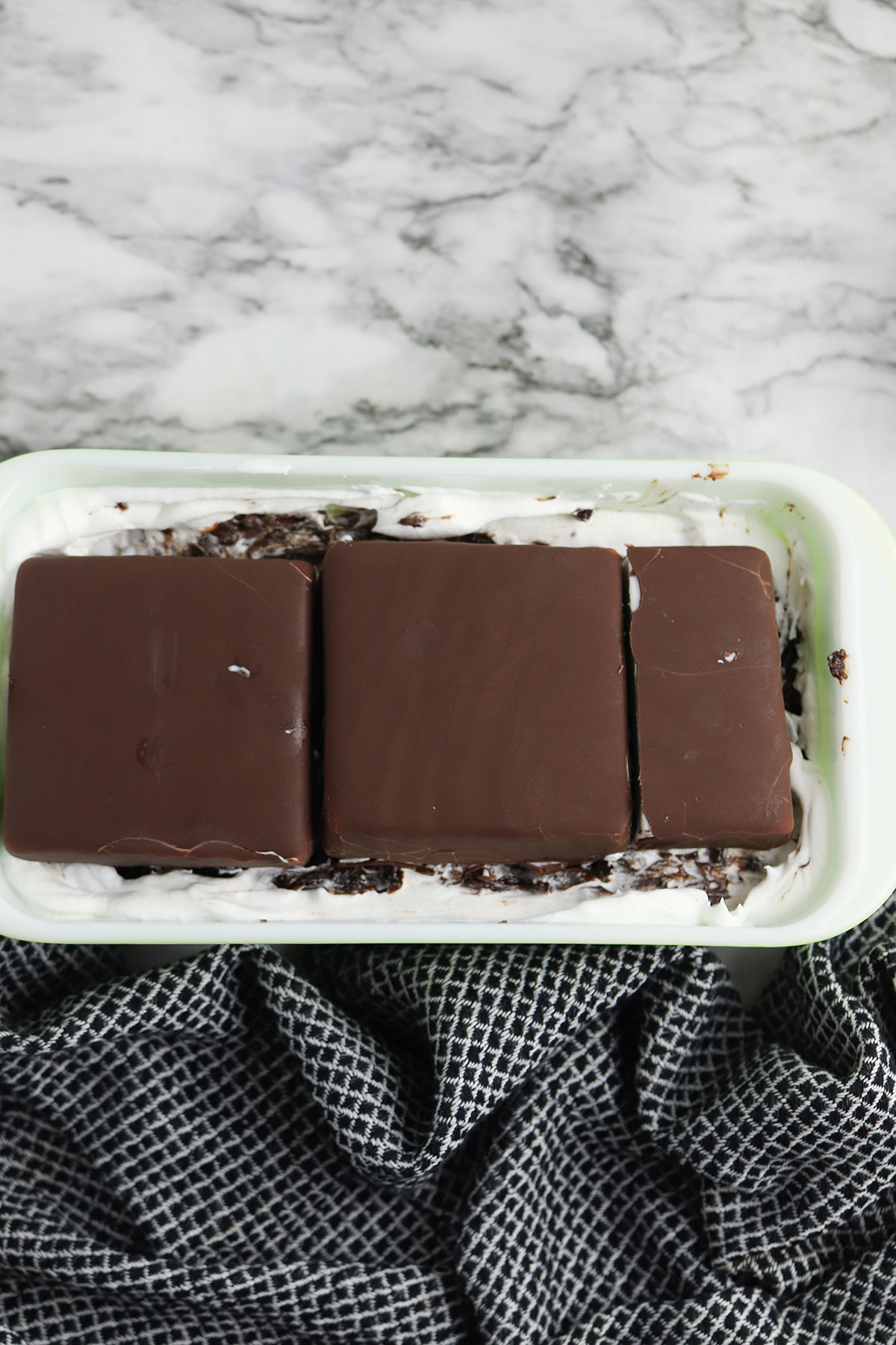 Second layer of Klondike bars placed over the Oreo hot fudge filling in the ice cream cake.