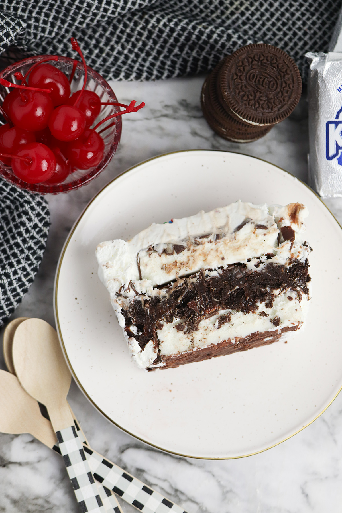 Overhead view of a slice of Klondike bar ice cream cake with whipped topping, Oreo filling, and chocolate layers.