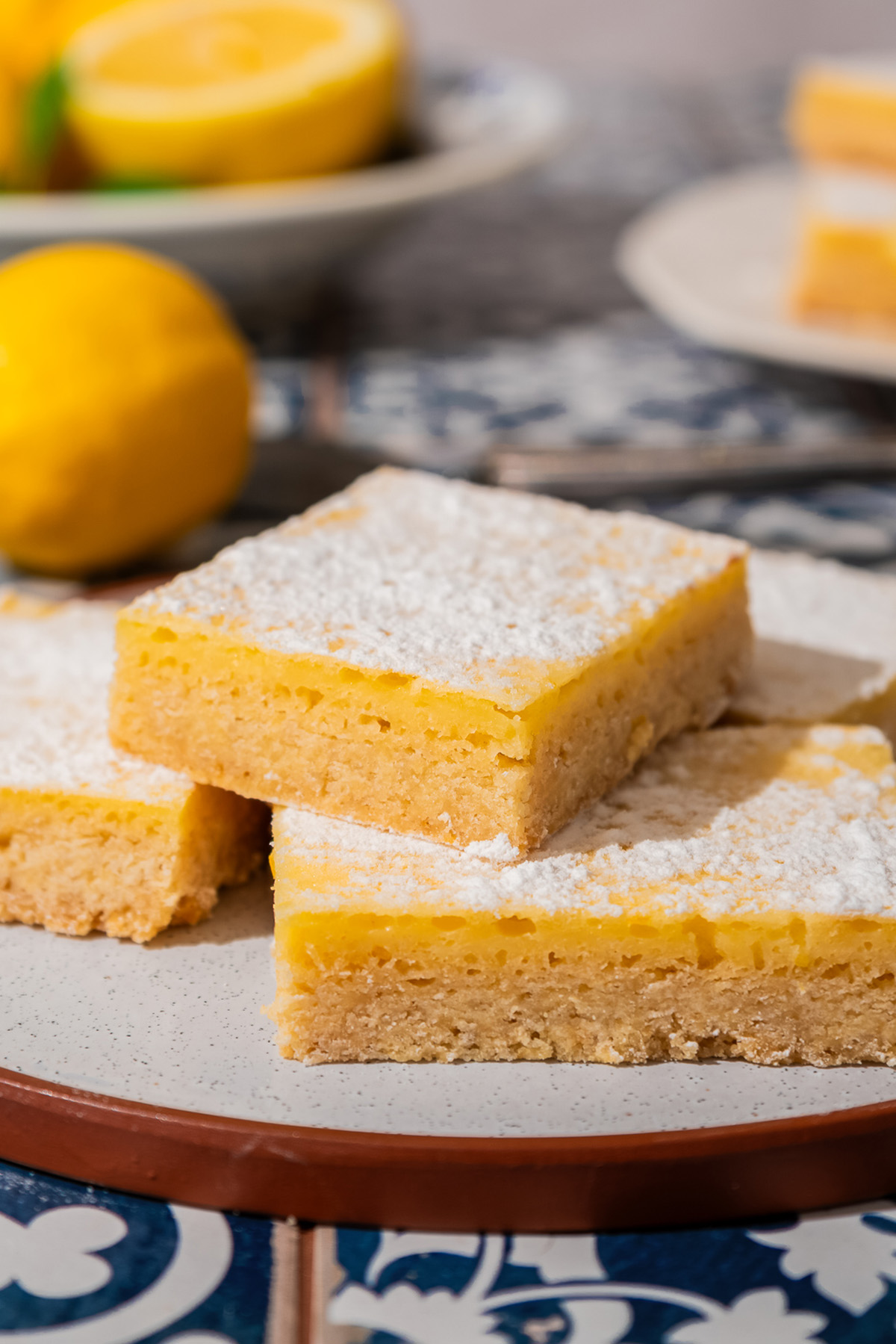 Close-up of sugar cookie lemon bars with lemon filling and powdered sugar on top.