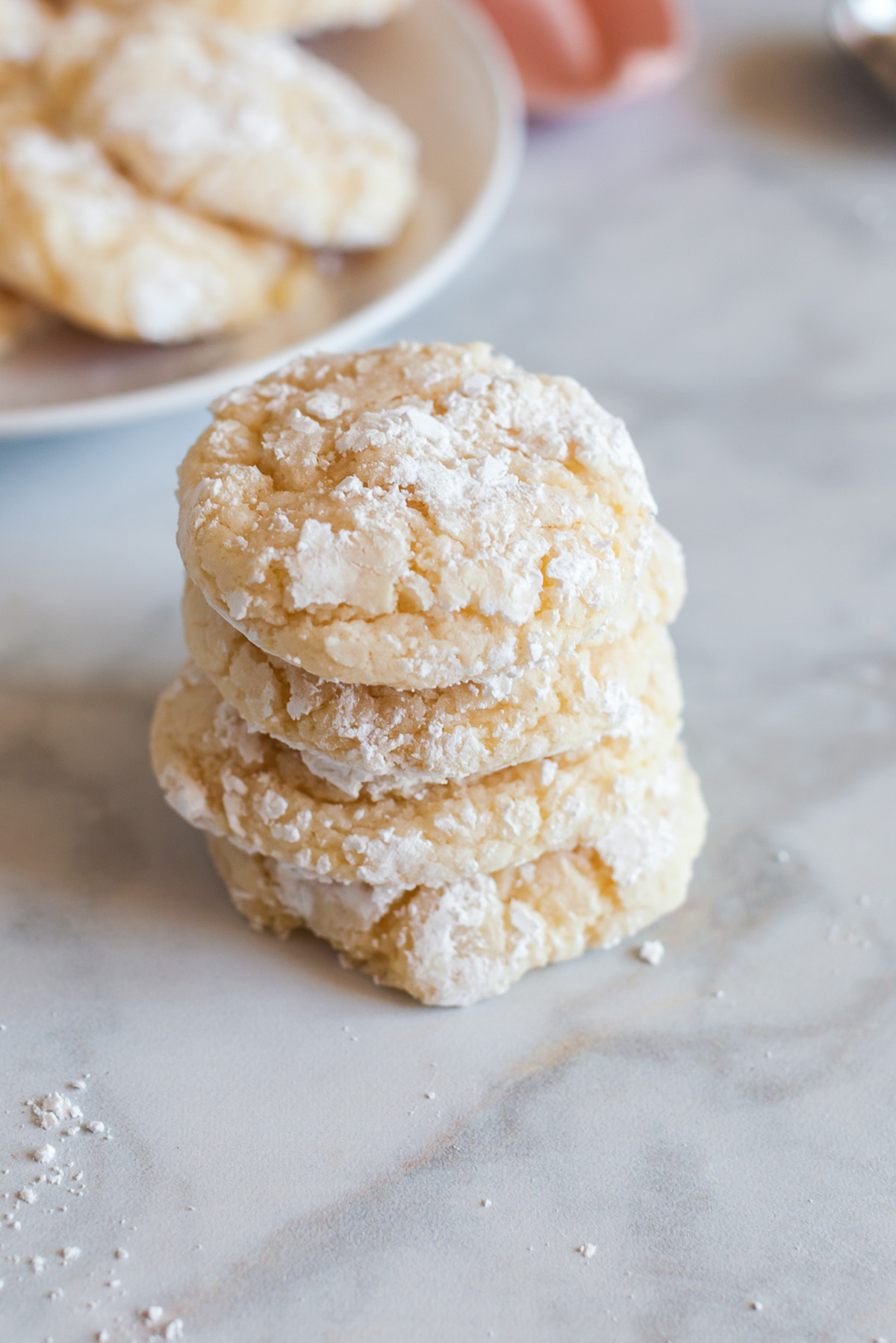 Stack of vanilla crinkle cookies showing soft centers and powdered sugar coated crackled tops.