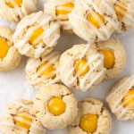 Close-up of lemon curd thumbprint cookies with icing drizzle highlighting the soft centers and crumbly texture.