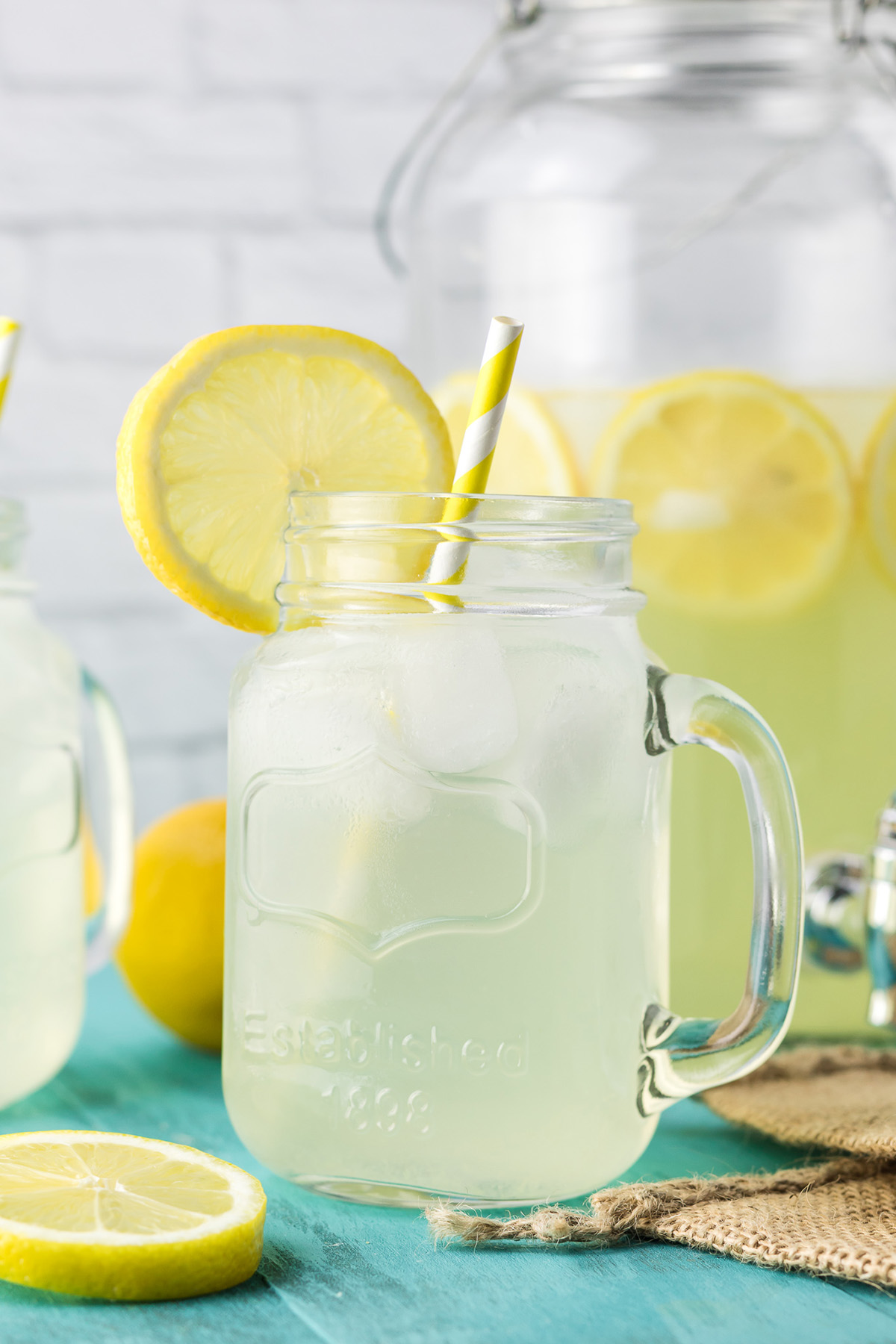 Easy spiked lemonade drink in a glass mason jar with lemon slice garnish.