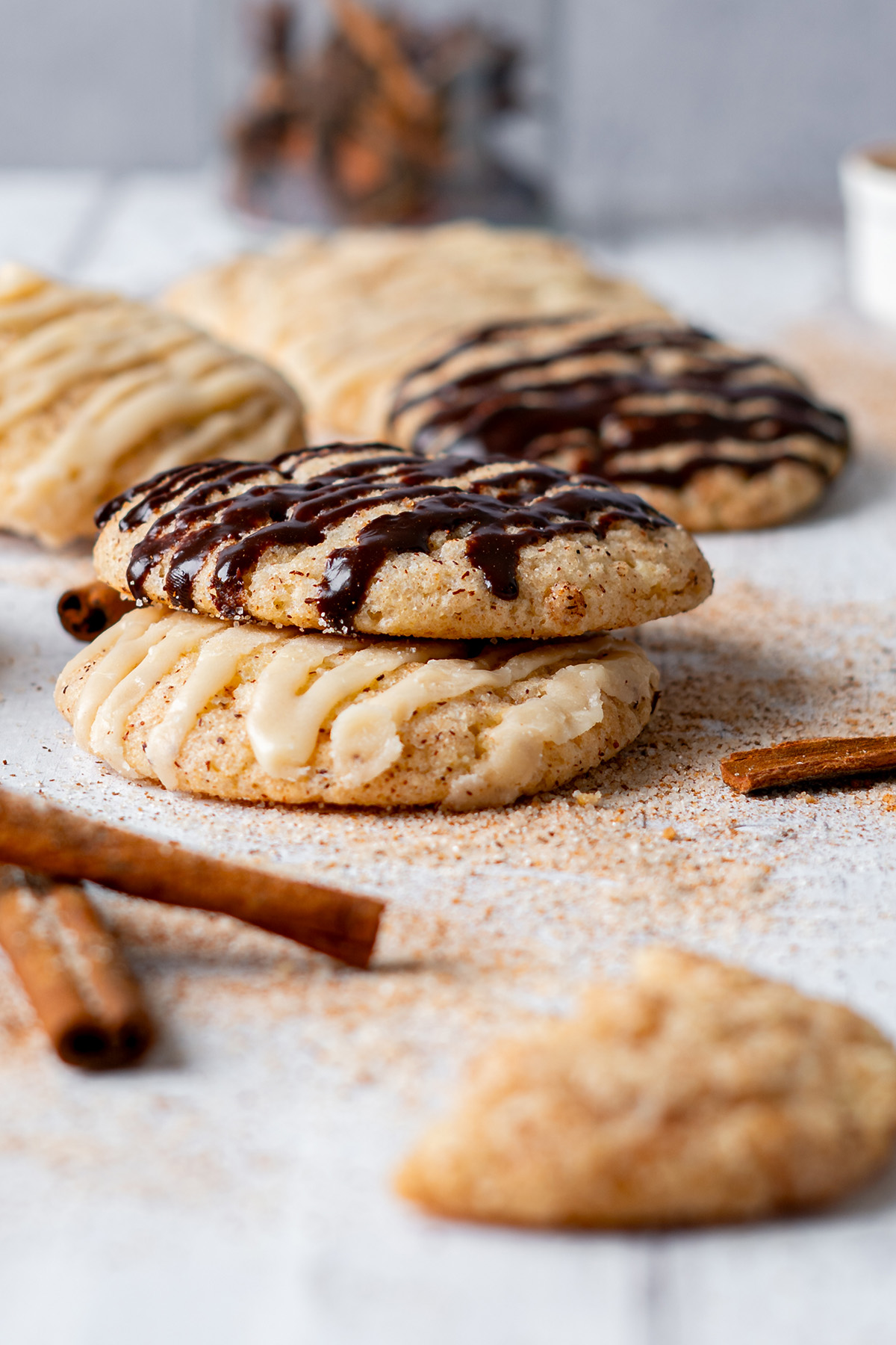 Cake mix churro cookies with caramel and chocolate drizzle served with cinnamon sticks.