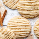 Close up of cinnamon churro cookies with caramel drizzle and cinnamon sticks.