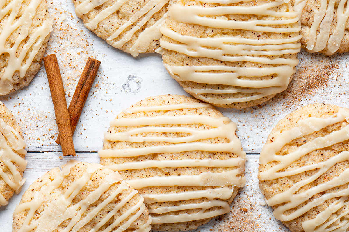 Close up of cinnamon churro cookies with caramel drizzle and cinnamon sticks.