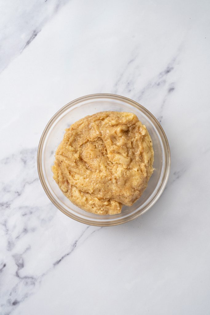 Thick cake mix churro cookie dough mixed with cinnamon in a glass bowl.