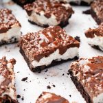 Chocolate and peanut butter rice krispie bars cut into squares with a gooey marshmallow layer and fudgy brownie bottom.