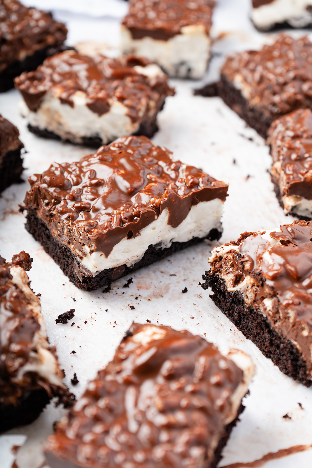 Layered marshmallow peanut butter rice krispie brownies with a fudgy brownie base and crunchy chocolate topping.