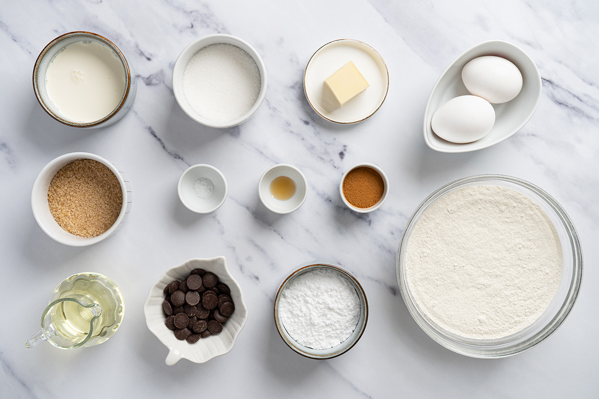 Ingredients for cake mix churro cookies including French vanilla cake mix, cinnamon, eggs, oil, butter, cream, and chocolate.