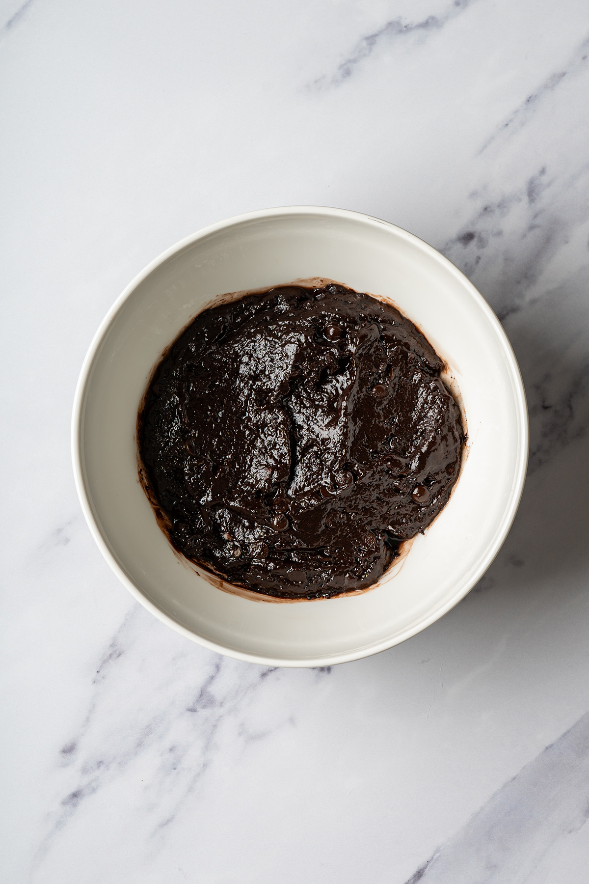 Fudgy brownie batter in a white bowl for marshmallow peanut butter rice krispie brownies.