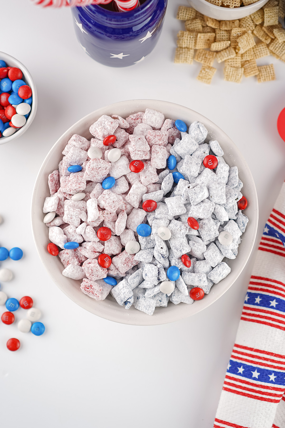Red and blue patriotic puppy chow mixed with red, white and blue M&Ms in a serving bowl.