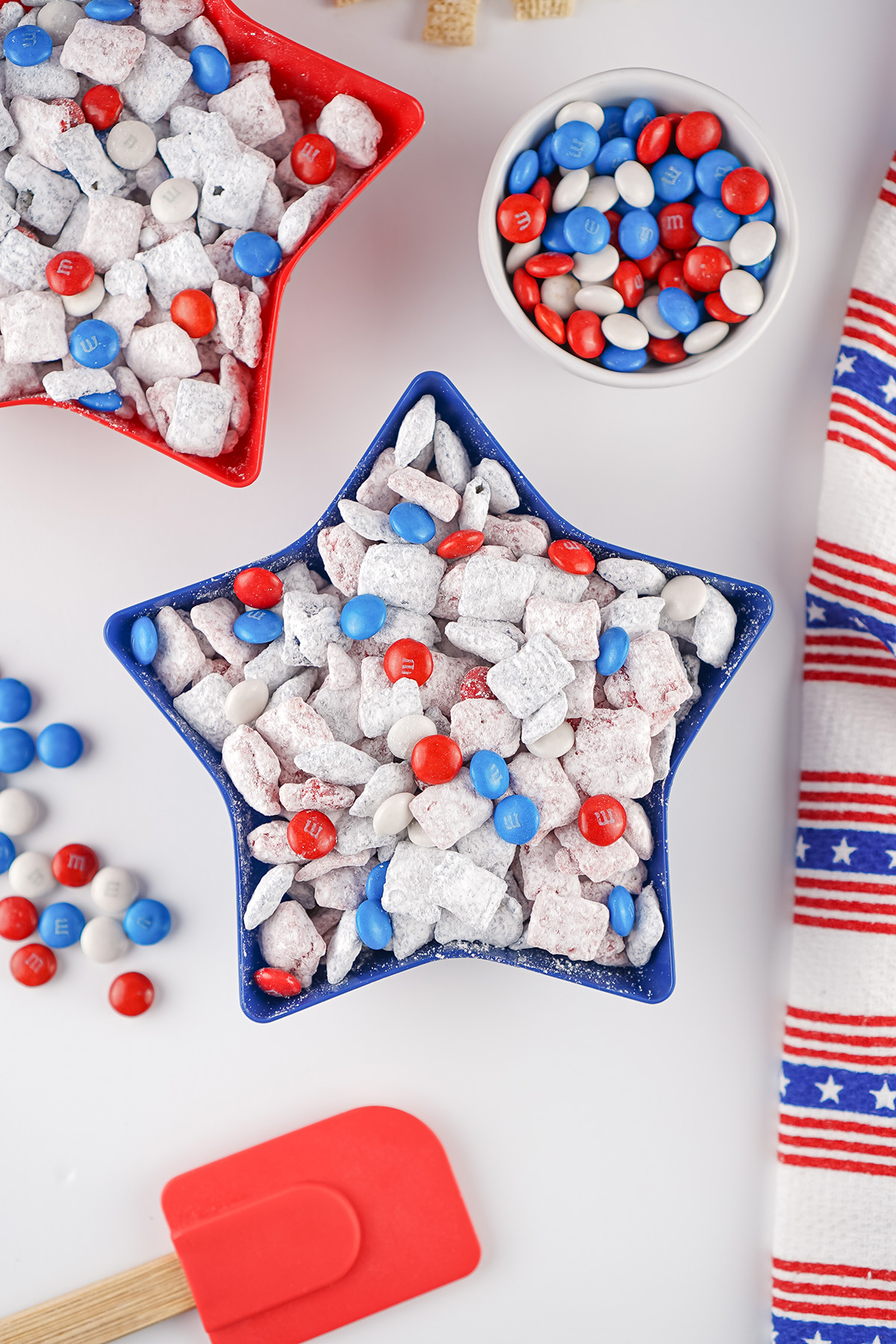 Patriotic muddy buddies served in a blue star shaped bowl with red, white and blue M&Ms.