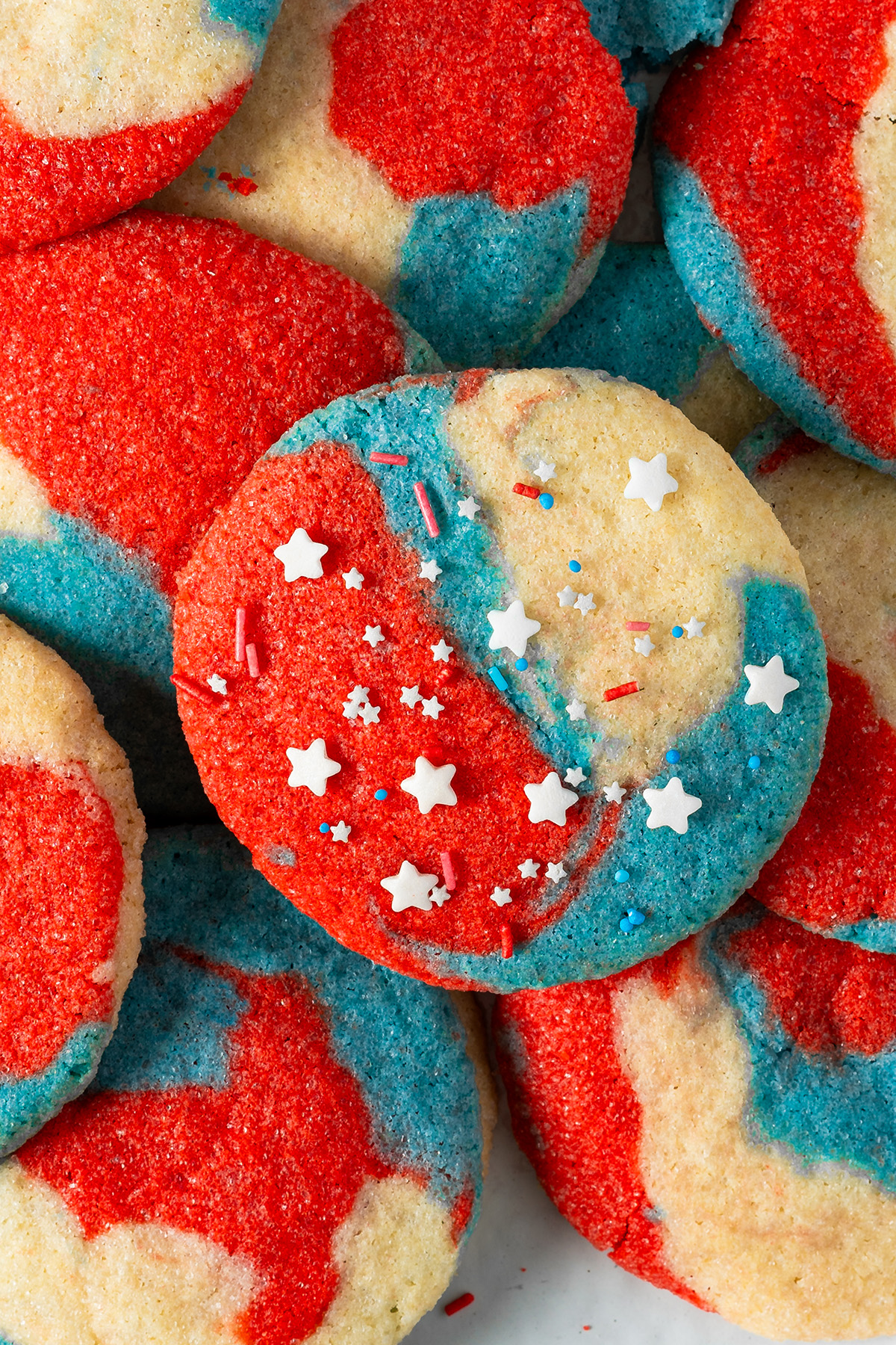 Patriotic sugar cookies with red, white and blue swirls and festive sprinkles.