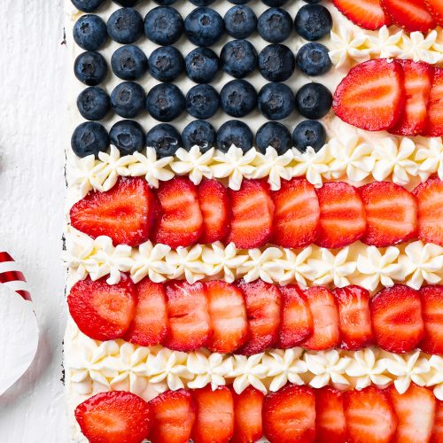 Close up of blueberry stars, strawberry stripes and piped frosting on flag brownies.