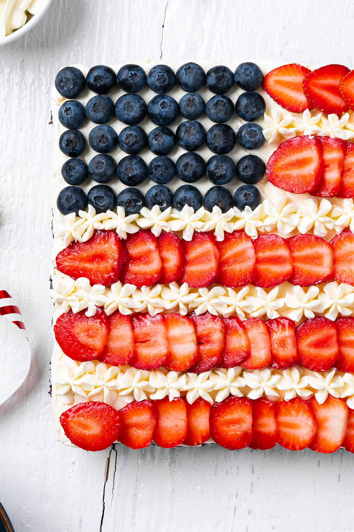 Close up of blueberry stars, strawberry stripes and piped frosting on flag brownies.