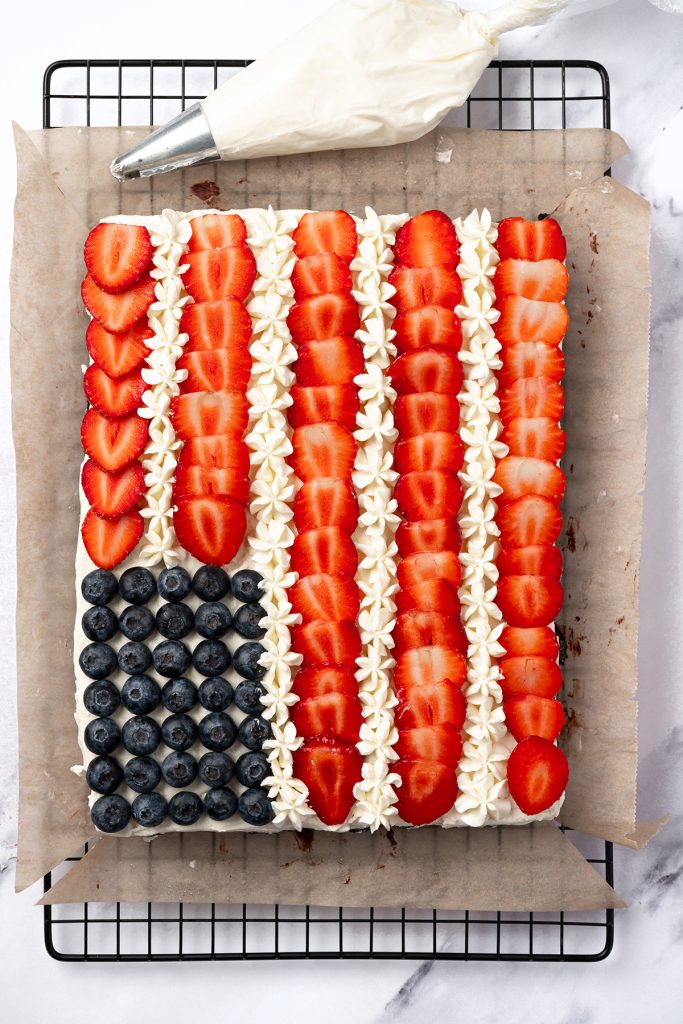 American flag brownies decorated with blueberries, strawberries and piped vanilla frosting.