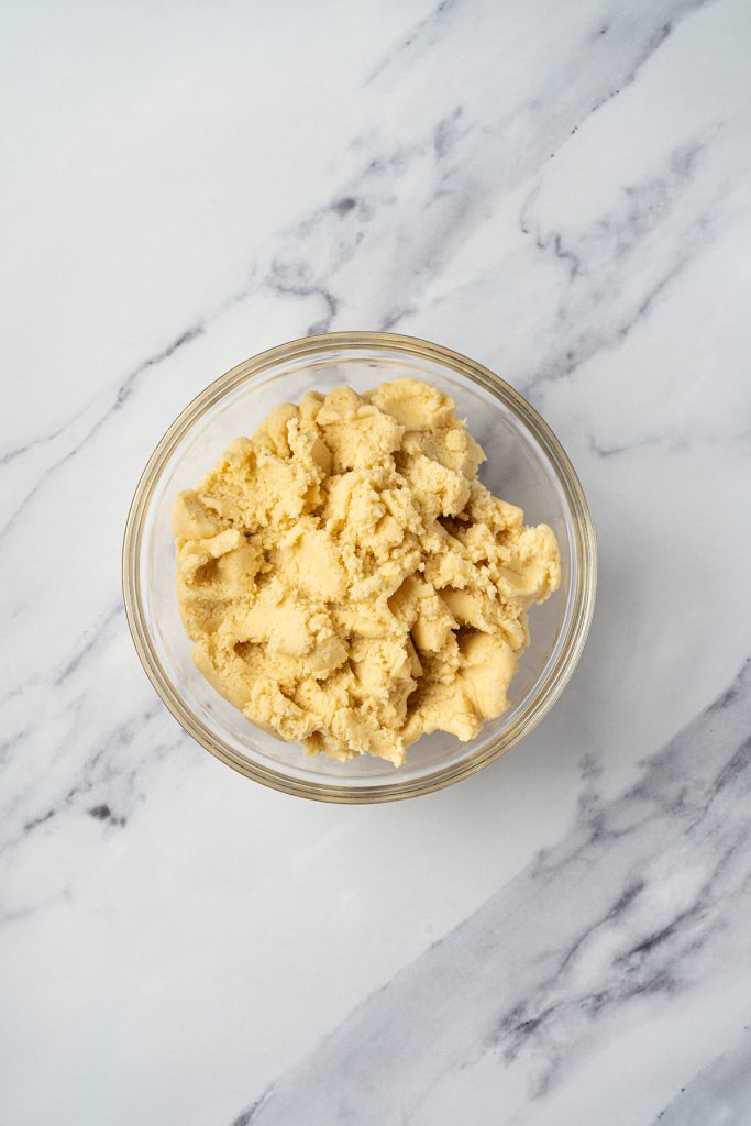 Plain sugar cookie dough in a glass bowl before coloring.