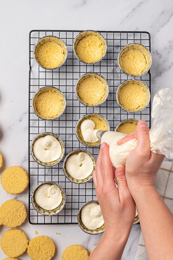 Vanilla frosting piped between layers of homemade dot cakes.