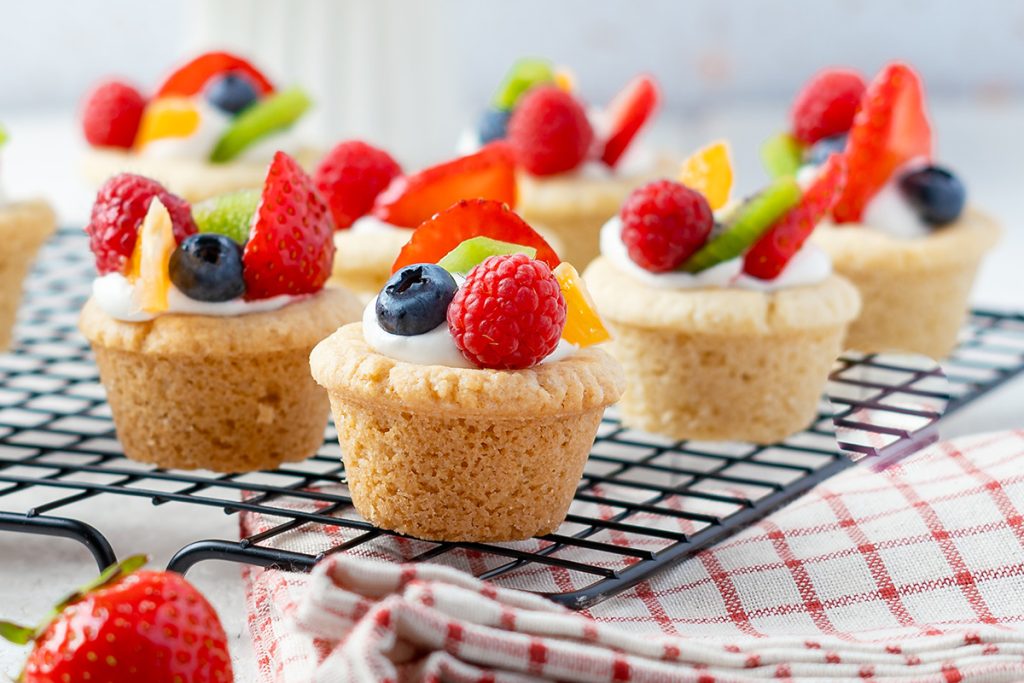 Close-up of fruit pizza cookie bites with strawberries, blueberries, kiwi, and mandarin oranges.