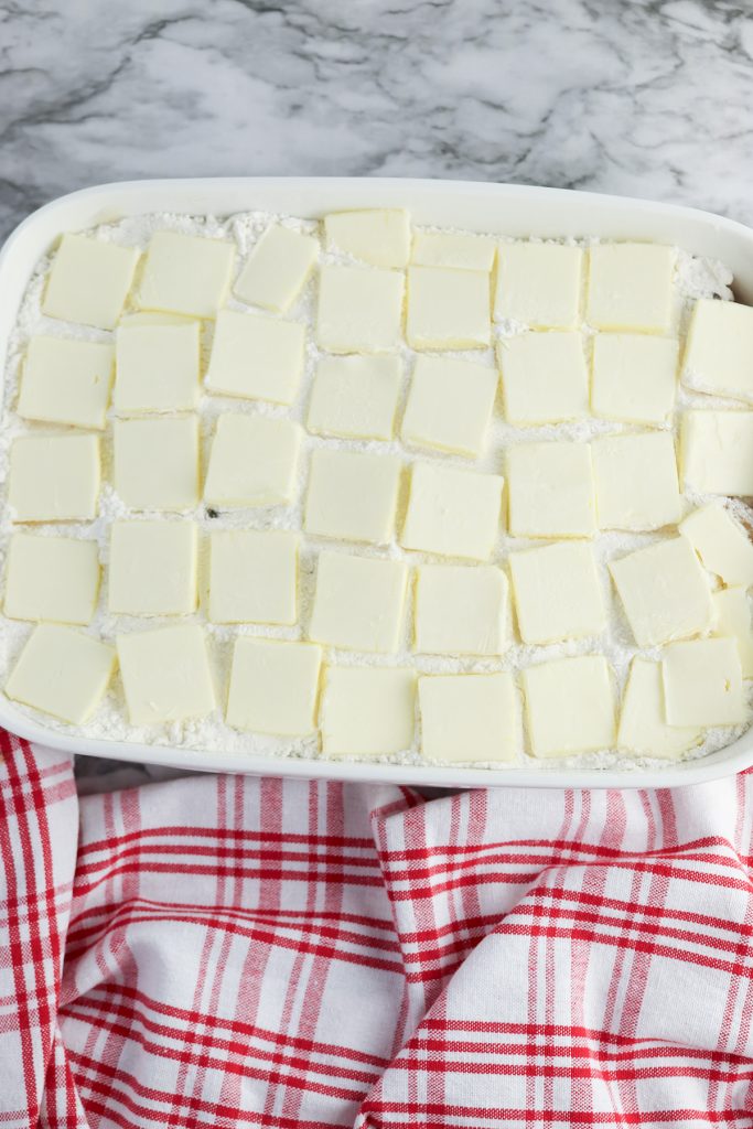 Slices of butter arranged over the cake mix layer for Cinnamon Toast Crunch apple dump cake.